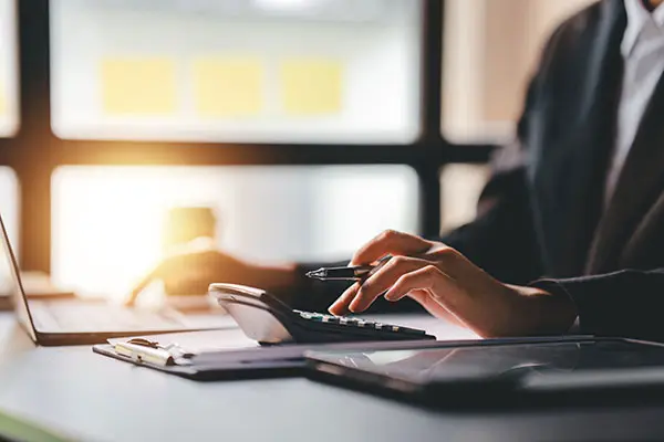 woman working on a laptop computer and calculator in a modern office
