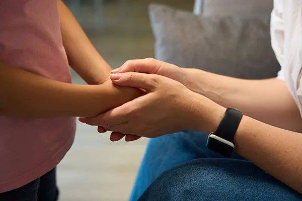 caring and loving mother holding hands of her little sweet child