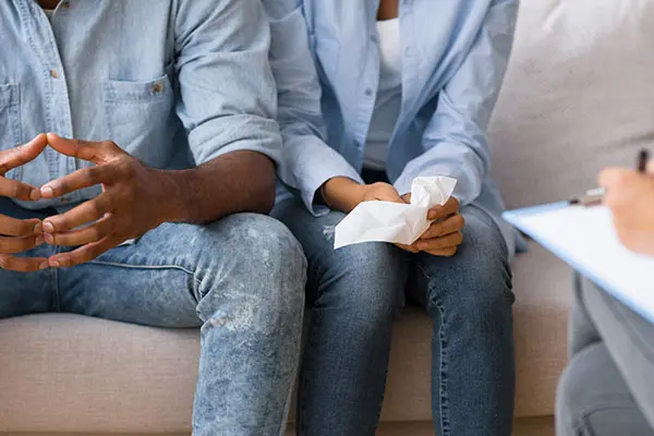 couple with marital trouble listening to advice sitting on sofa