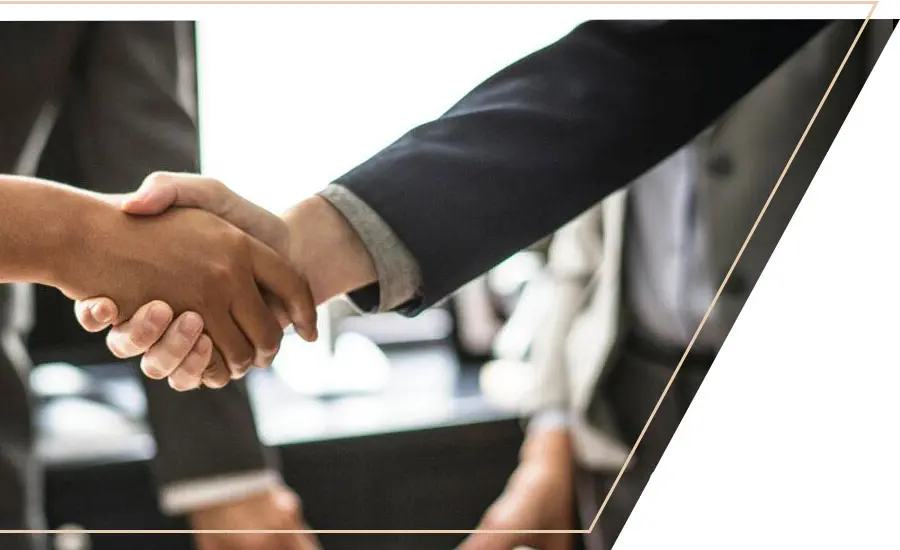 business professionals shake hands at office meeting
